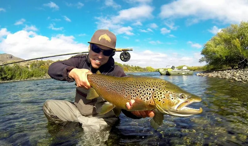 Pescador con una gran trucha marrón durante una salida de pesca con mosca en el río Limay, Patagonia